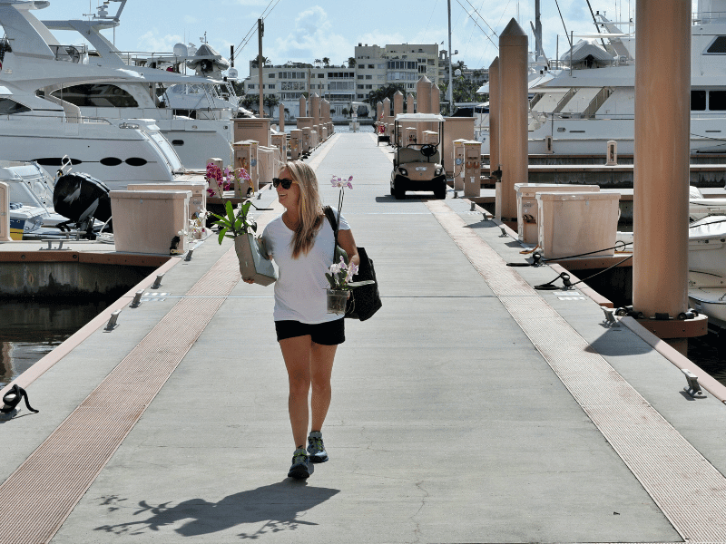 yacht stewardess carrying flowers down the dock